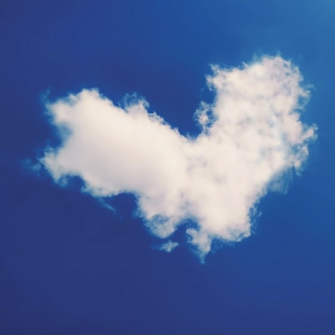 A heart-shaped cloud in a blue sky